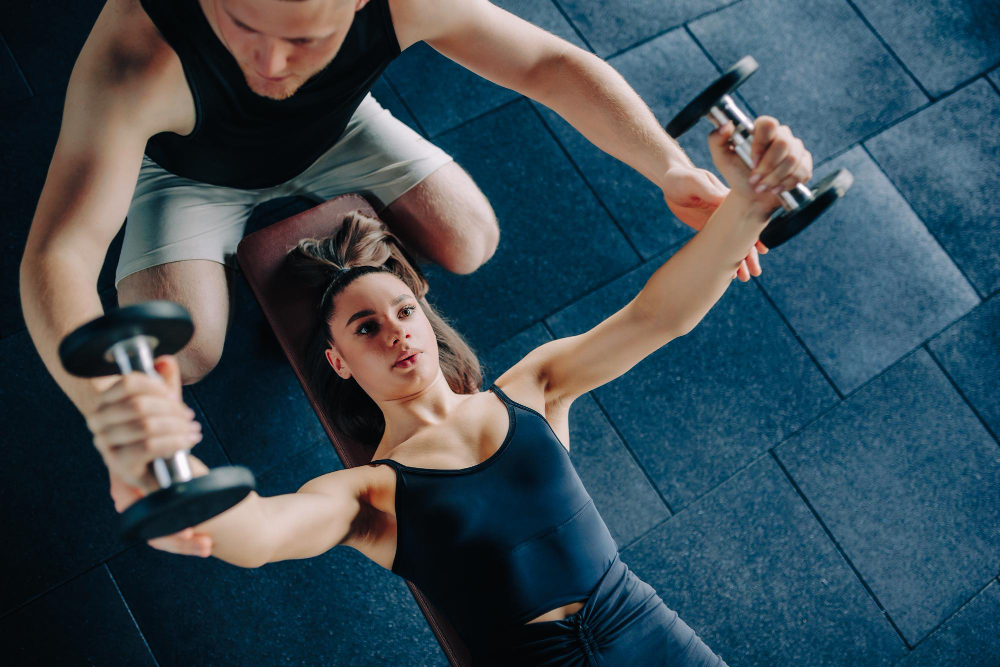 Personal training sessie waarbij een coach een deelnemer begeleidt in oefeningen, gericht op persoonlijke doelen en fitnessverbetering.